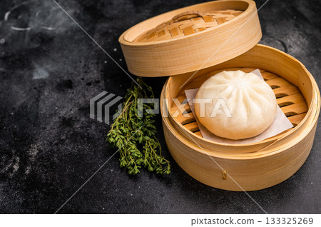 Chinese Bao or Baozi bun with meat in bamboo steamer. black background. top view Chinese Bao or Baozi bun with meat in bamboo steamer. black background. top view 133325269