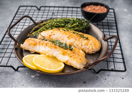 Baked Cod fish fiilet, fried whitefish meat. Grey background. top view Baked Cod fish fiilet, fried whitefish meat. Grey background. top view 133325289