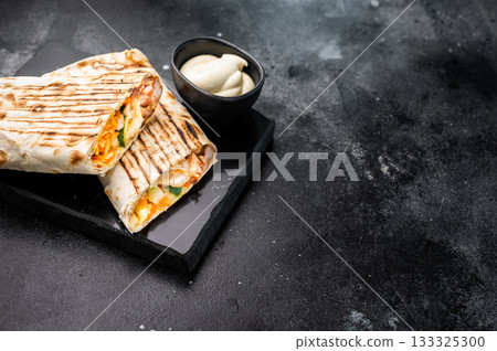 Oriental Doner kebab wrap, Shawarma with beef meat and salad. black background. top view Oriental Doner kebab wrap, Shawarma with beef meat and salad. black background. top view 133325300