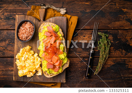 Sandwich with smoked salmon, trout, avocado and red caviar. wooden background. top view 133325311