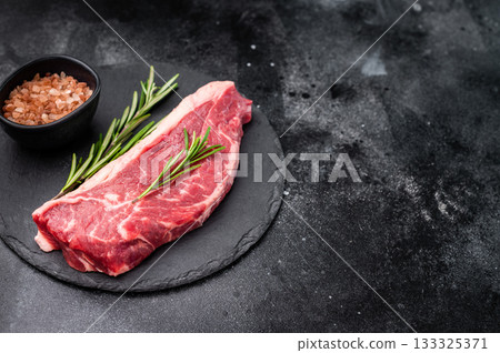 Fresh raw striploin New York steak, perfect for grilling or pan searing, ideal for a delicious homemade meal. black background. top view 133325371