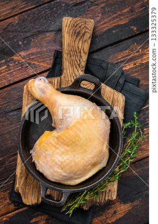 Raw farm chicken leg in a skillet ready for cooking, poultry fresh meat on wooden background, top view. 133325379