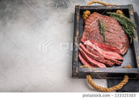Close up of a perfectly grilled rump or top sirloin beef steak, highlighting its tenderness and flavorful crust, ideal for meat enthusiasts. white background. top view 133325383