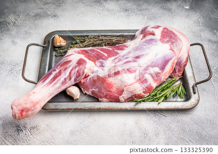 Uncooked fresh goat shoulder leg with rich marbling, ideal for gourmet dishes and family feasts. grey background. top view 133325390