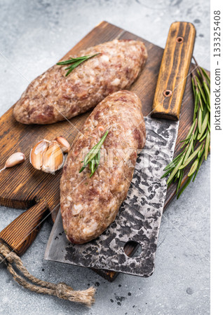 Succulent raw kofta kebab pieces marinated in spices, ideal for grilling enthusiasts looking to elevate their barbecue game. grey background. top view 133325408