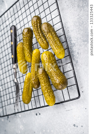 Crunchy pickled cucumbers, bursting with flavor, perfect for sandwiches, salads, or as a tangy snack. grey background 133325443