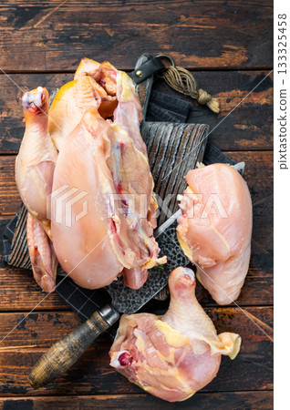 Raw chicken pieces on a cutting board, ready for cooking 133325458