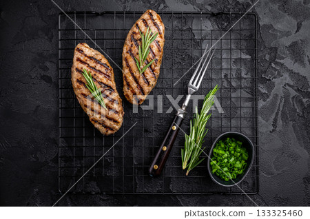 Grilled kofta kebabs made from spiced minced meat, perfectly grilled and served with fresh herbs and tangy sauce. black background. top view 133325460