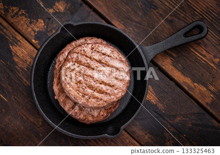 Deliciously charred grilled meat burger patty on the grill, perfect for satisfying cravings at any cookout. wooden background. top view Deliciously charred grilled meat burger patty on the grill, perfect for satisfying cravings at any cookout. wooden background. top view 133325463