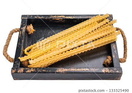 Delicate raw mafaldine pasta noodles, perfect for tossing with fresh ingredients and savory sauces. isolated on white background. top view Delicate raw mafaldine pasta noodles, perfect for tossing with fresh ingredients and savory sauces. isolated on white background. top view 133325490