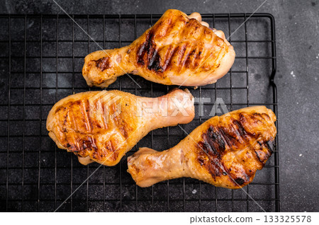 Savory BBQ chicken legs, drumsticks beautifully caramelized on the grill, ready to be enjoyed with your favorite dipping sauce. black background. top view 133325578
