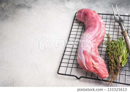 Uncooked pork loin fillet, raw tenderloin ready to be seasoned and transformed into a delicious centerpiece for dinner. white background. top view Uncooked pork loin fillet, raw tenderloin ready to be seasoned and transformed into a delicious centerpiece for dinner. white background. top view 133325613