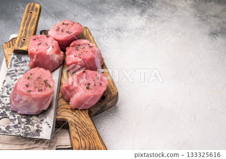 Juicy uncooked pork medallion, raw loin meat a versatile choice for stir fries or savory roasts in any cuisine. white background. top view 133325616