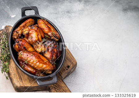 Grilled chicken wings smothered in sweet and sour sauce, poultry meat. white background. top view Grilled chicken wings smothered in sweet and sour sauce, poultry meat. white background. top view 133325619
