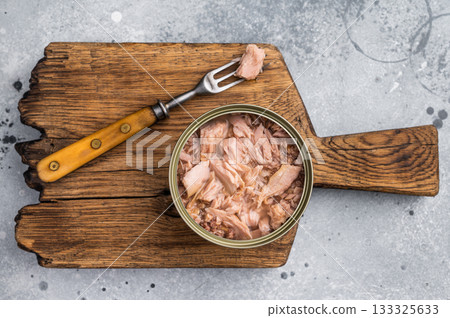 Delicious canned tuna in olive oil, ideal for salads, sandwiches, or as a savory snack on the go. grey background. top view 133325633