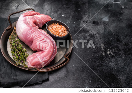 Fresh pork tenderloin fillet, showcasing its lean cut, perfect for marinating and grilling to juicy perfection. black background. top view Fresh pork tenderloin fillet, showcasing its lean cut, perfect for marinating and grilling to juicy perfection. black background. top view 133325642