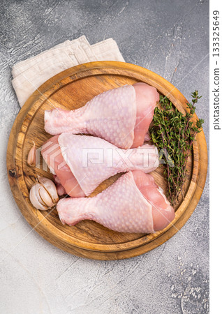 Raw poultry drumsticks, chicken legs ready for cooking with herbs and spices. white background. top view Raw poultry drumsticks, chicken legs ready for cooking with herbs and spices. white background. top view 133325649