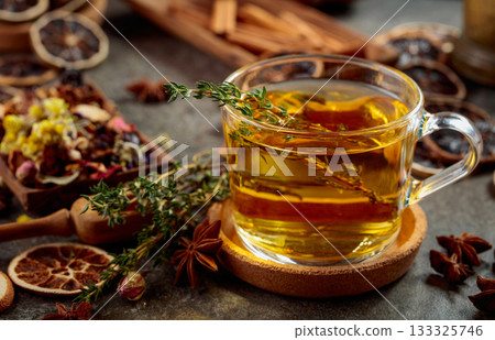 Cup of herbal tea with ingredients on the kitchen table. Cup of herbal tea with ingredients on the kitchen table. 133325746