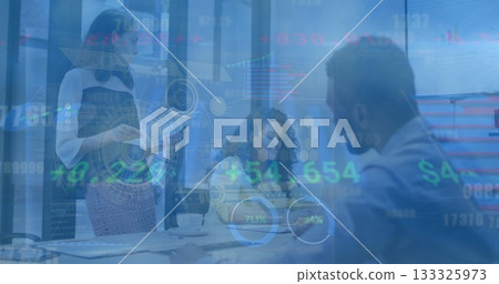 Presenting business professionals holding tablet and writing notes at table in office, with laptops 133325973