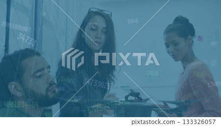 Three colleagues examining multirotor drone parts at conference table, with whiteboard notes Three colleagues examining multirotor drone parts at conference table, with whiteboard notes 133326057