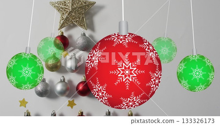 Hanging baubles in studio, arranging red snowflake ornament with green spheres and golden star 133326173