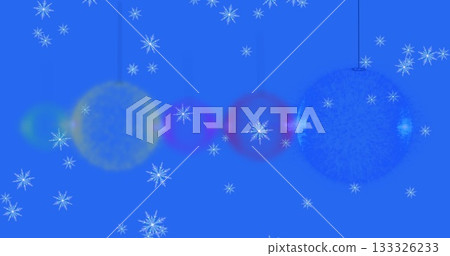 Displaying glowing yellow magenta blue ornaments hanging on blue backdrop, with white snowflakes Displaying glowing yellow magenta blue ornaments hanging on blue backdrop, with white snowflakes 133326233