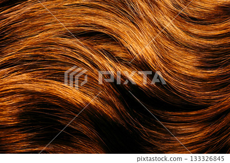 Macro texture of wavy hair strands with glossy warm tone. Beauty and haircare background for salon products and dermatology themes. Macro texture of wavy hair strands with glossy warm tone. Beauty and haircare background for salon products and dermatology themes. 133326845
