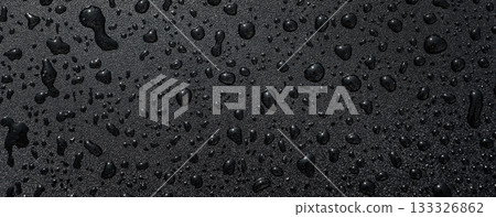 Macro droplets on dark hydrophobic surface showing water beading. Premium waterproof background for technology, car care and outdoor gear visuals. 133326862
