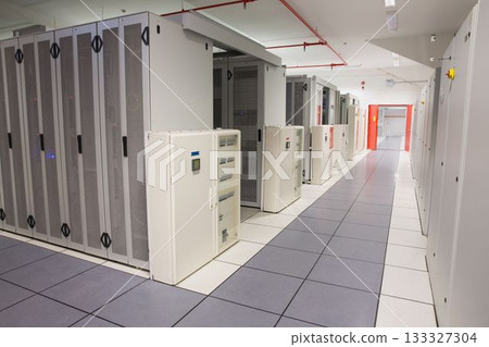 Server racks and PDUs lining 3D render data center corridor, showing tiles, fire piping and lights Server racks and PDUs lining 3D render data center corridor, showing tiles, fire piping and lights 133327304