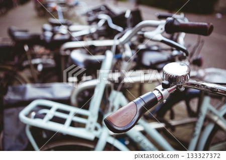 Showing street-side flat design bike handlebar featuring brown grip with chrome bell Showing street-side flat design bike handlebar featuring brown grip with chrome bell 133327372