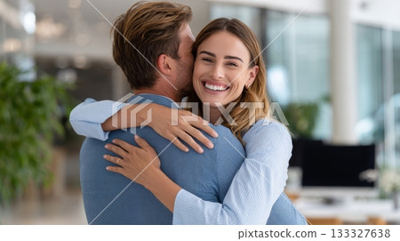 Young caucasian female hugging caucasian male in modern office setting 133327638