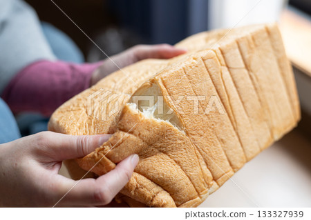 一個人手裡拿著軟麵包 一個人手裡拿著軟麵包 133327939