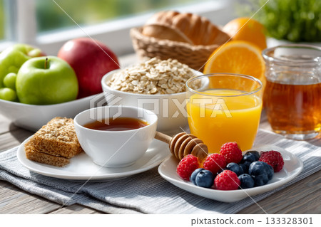 Healthy Balanced Breakfast with Fresh Fruits, Oats, Juice and Tea Served on a Sunny Morning Table Setting 133328301