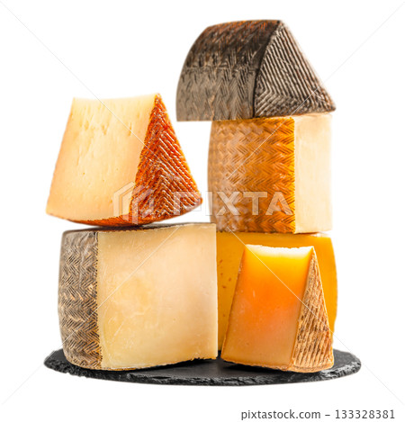 Assorted pieces of Spanish cheese stacked on slate plate isolated on white, traditional Manchego and aged sheep cheeses with rustic rind, gourmet dairy food concept advertising or banner 133328381