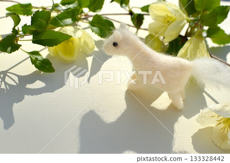 Wool felt white horse and winter-flowering clematis 133328442