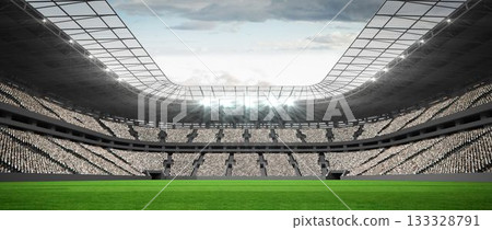 Flat green grass football pitch is extending under roof canopy with floodlights against cloudy sky 133328791