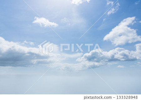 White cumulus clouds are drifting over gradient blue flat design sky with faint haze White cumulus clouds are drifting over gradient blue flat design sky with faint haze 133328948