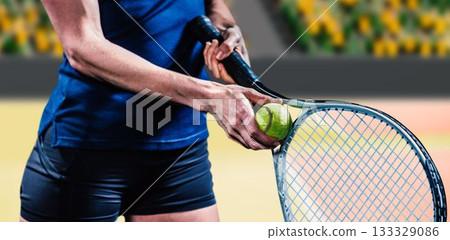 Midsection of female tennis player holding racket Midsection of female tennis player holding racket 133329086