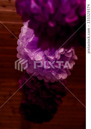 Purple paper pompoms hanging for wedding reception decoration Purple paper pompoms hanging for wedding reception decoration 133329374