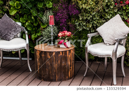 Wedding lounge area decorated with flowers and candle on a wooden table 133329394
