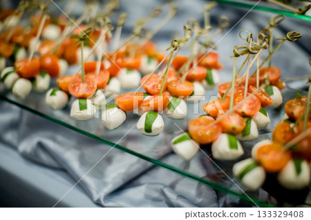 Catering preparing delicious cherry tomatoes and mozzarella appetizers for wedding Catering preparing delicious cherry tomatoes and mozzarella appetizers for wedding 133329408