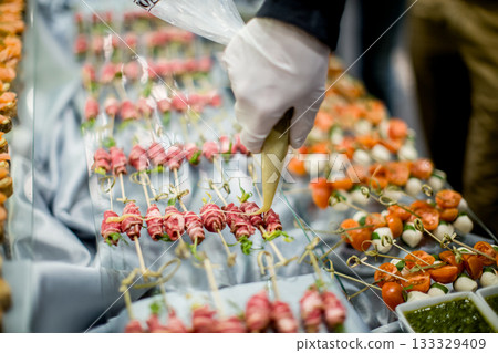 Chef garnishing delicious appetizers for wedding reception buffet 133329409