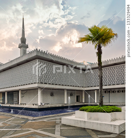 Masjid Negara, National Mosque of Malaysia: Exterior with minaret, geometric patterns, and palm tree, Kuala Lumpur, Malaysia. Masjid Negara, National Mosque of Malaysia: Exterior with minaret, geometric patterns, and palm tree, Kuala Lumpur, Malaysia. 133329494