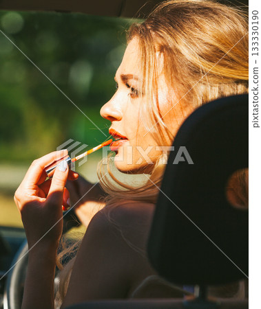 Girl apply make up while driving car. 133330190