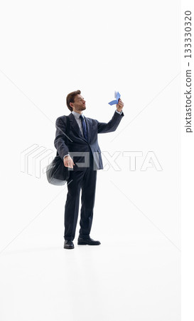 Businessman checking travel document with focused emotion in studio space 133330320