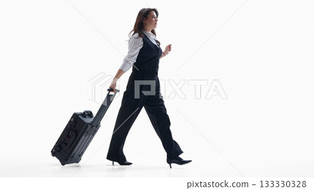 Confident businesswoman walking with rolling suitcase and professional mood Confident businesswoman walking with rolling suitcase and professional mood 133330328