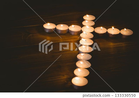 Lit candles in shape of cross Lit candles in shape of cross 133330550