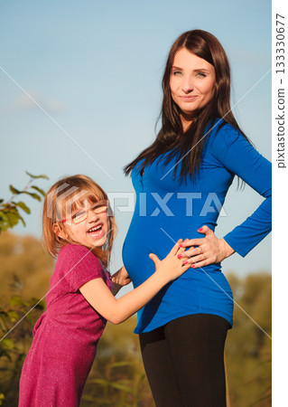 pregnant woman with her daughter in park outdoor pregnant woman with her daughter in park outdoor 133330677
