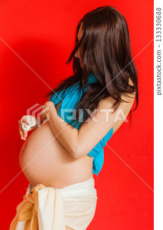 Adult woman showing her pregnant belly Adult woman showing her pregnant belly 133330688
