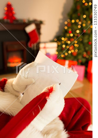 Santa Claus is writing gift list with quill pen in flat-design living room, with Christmas tree Santa Claus is writing gift list with quill pen in flat-design living room, with Christmas tree 133330749